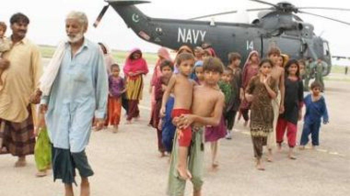 Un grupo de niños son evacuados junto a sus familiares por la Armada pakistaní.