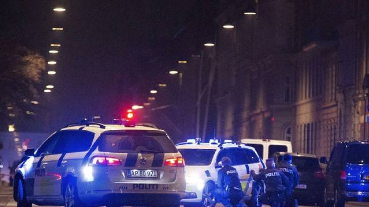 La policía danesa detrás de los coche patrulla en las calles de Copenhage.