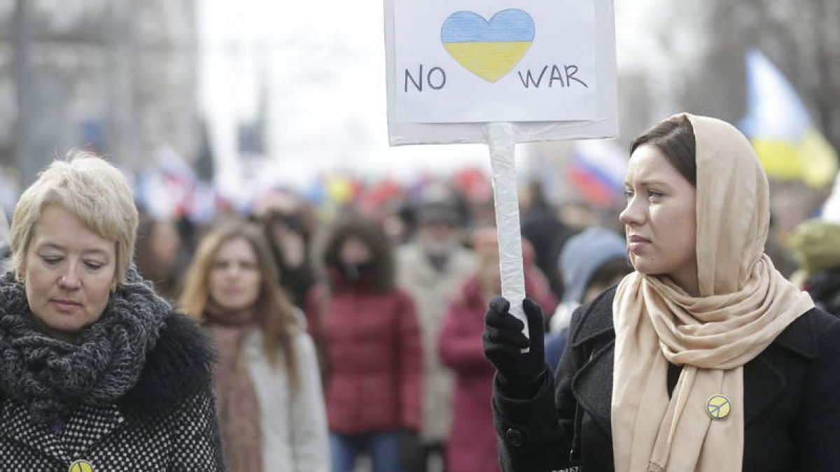 Una rusa porta una pancarta en contra de la guerra y de las acciones militares en Ucrania.