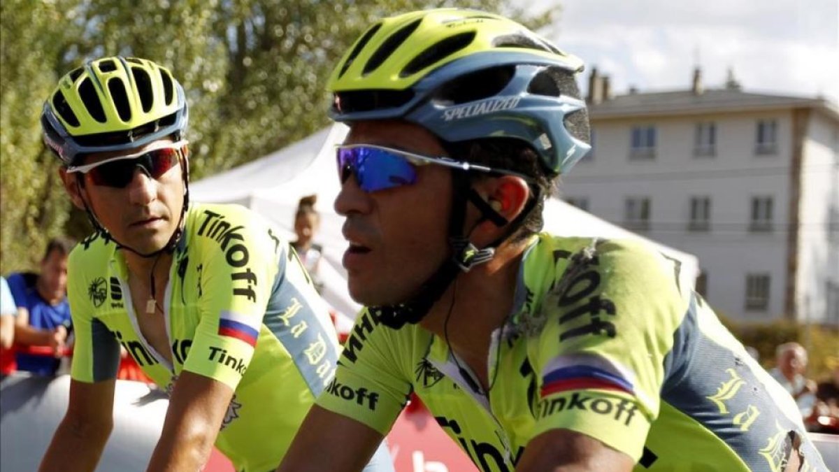 Alberto Contador cruza la meta de Puebla de Sanabria tras caer, acompañado por Jesús Hernández.