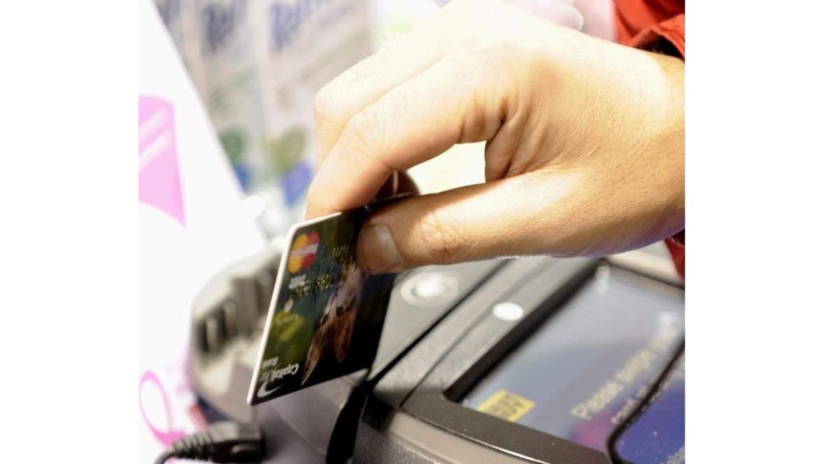 Un cliente pasa su tarjeta por el terminal de un comercio. J. LANE