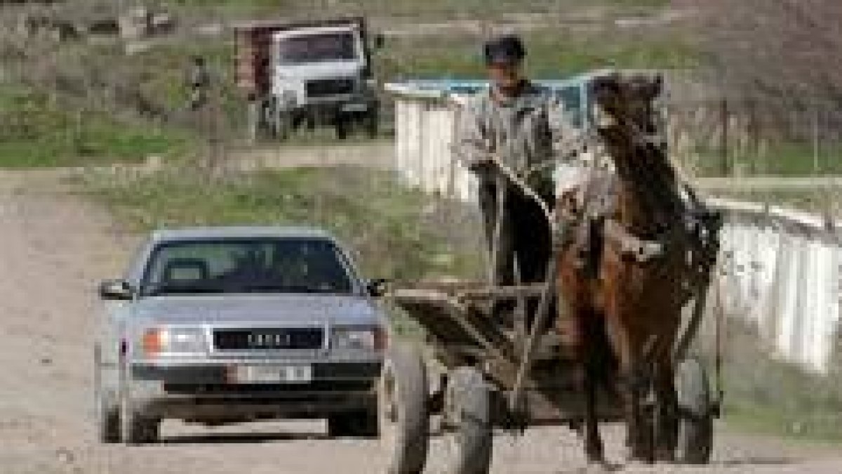 Un campesino circula delante de un automóvil en una carretera a 50 kilómetros de la capital, Bishkek