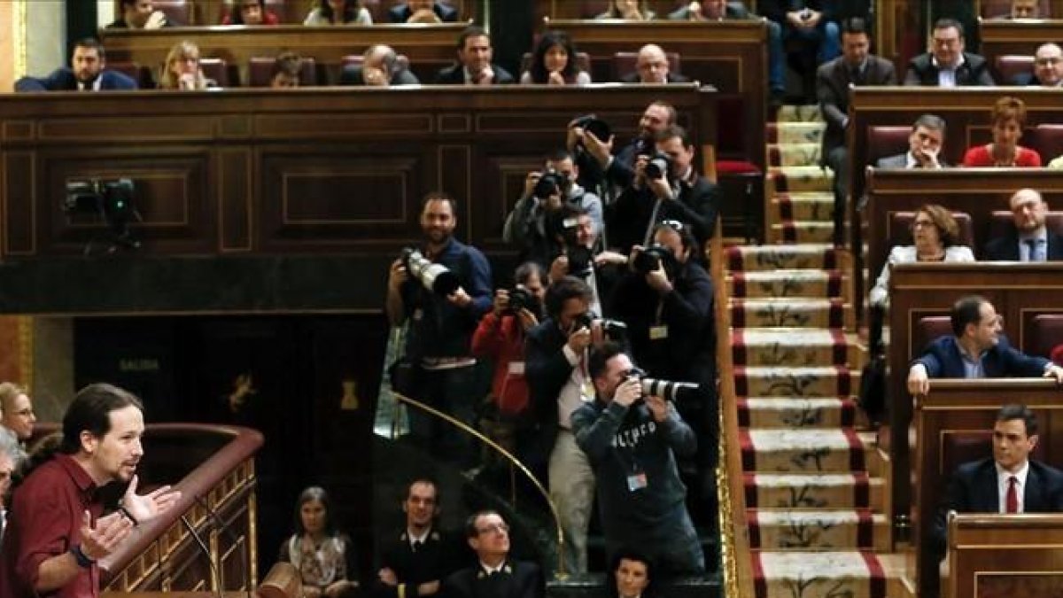 Pablo Iglesias se dirige al hemiciclo en la segunda sesión del debate de investidura con Pedro Sánchez sentado en su escaño.