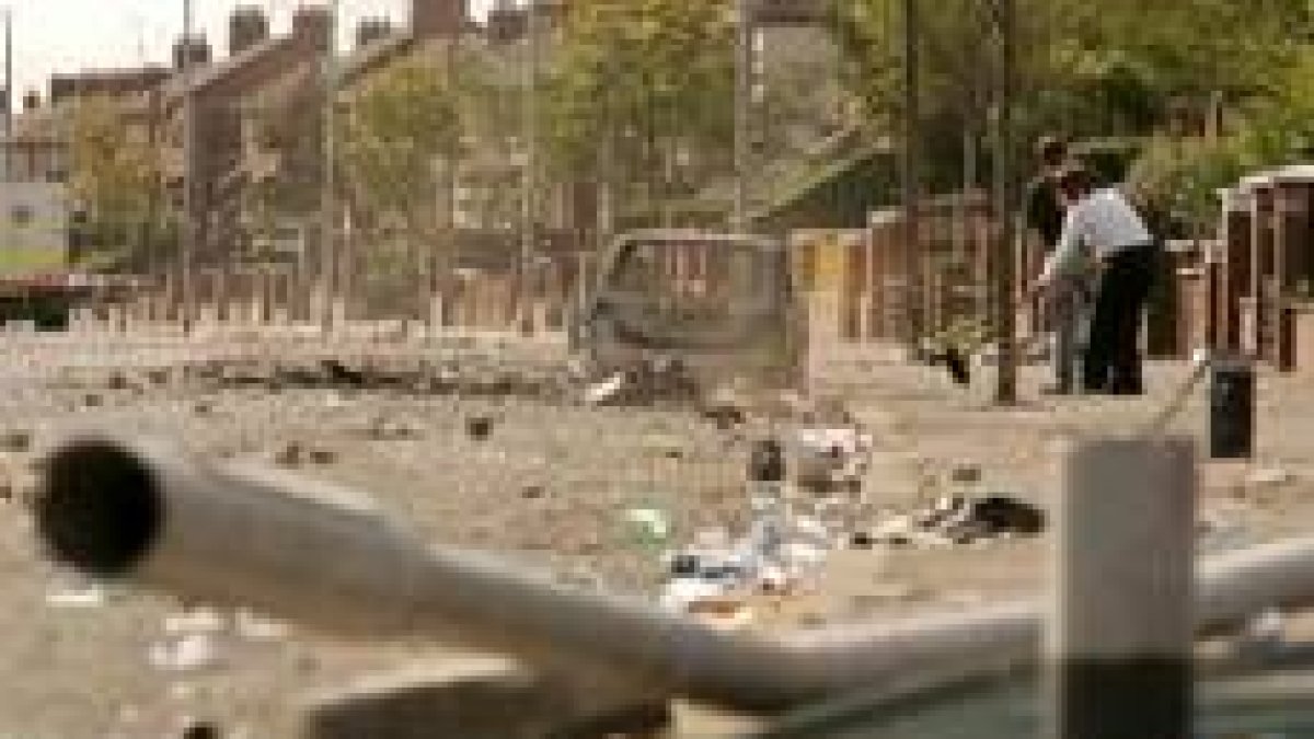Unos protestantes limpian una calle de la zona lealista de Belfast, tras los disturbios del sábado