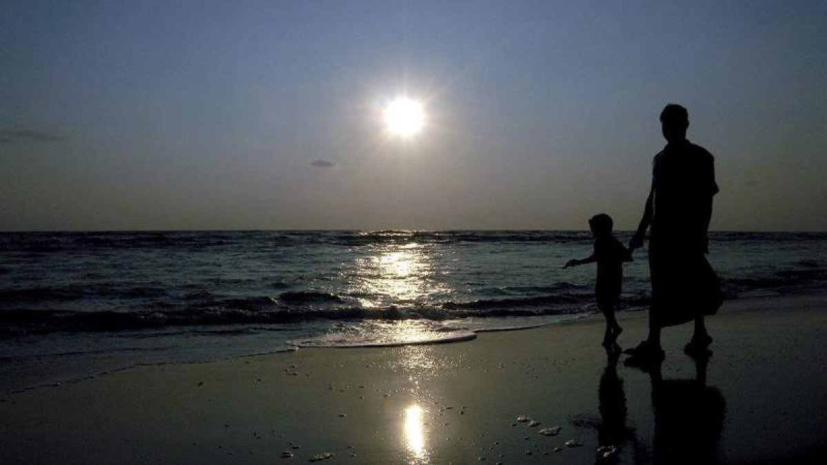 Un hombre y su hijo pasean por la playa en una de las islas de Andamán, en la India. MANJUNATH KIRAN