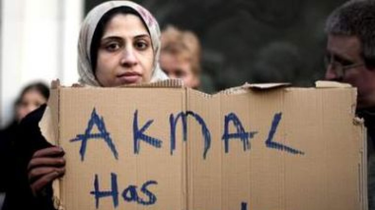 Una defensora de Akmal sostiene un cartel que dice que el británico sufre trastorno bipolar.