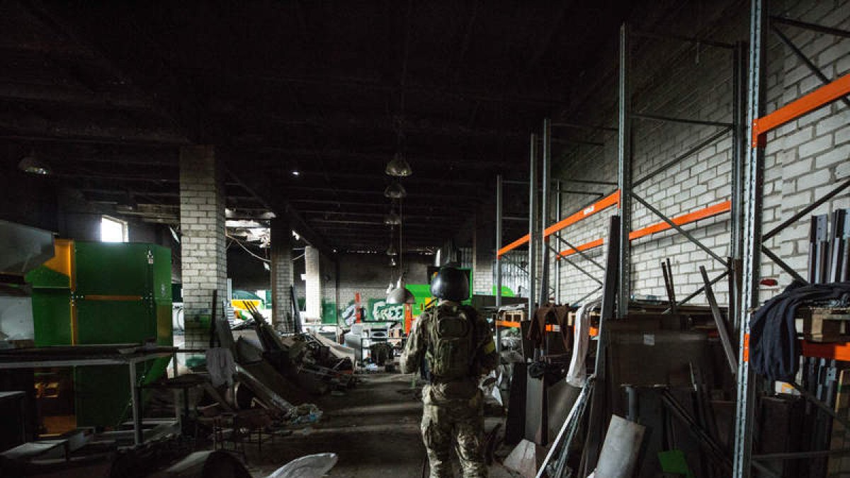 Un soldado ucraniano patrulla en una fábrica destruida por misiles rusos en Járkov. ESTEBAN BIBA