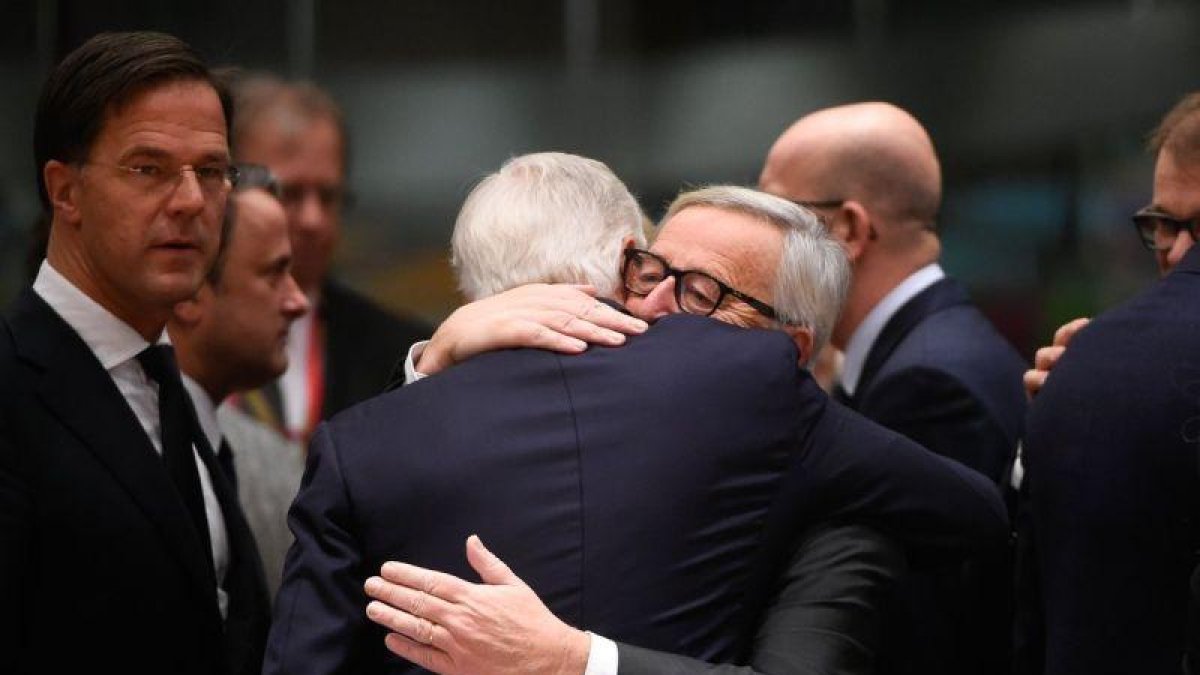 Juncker abraza a Barnier (de espaldas), a su llegada a la cumbre del Consejo Europeo, este domingo en Bruselas.