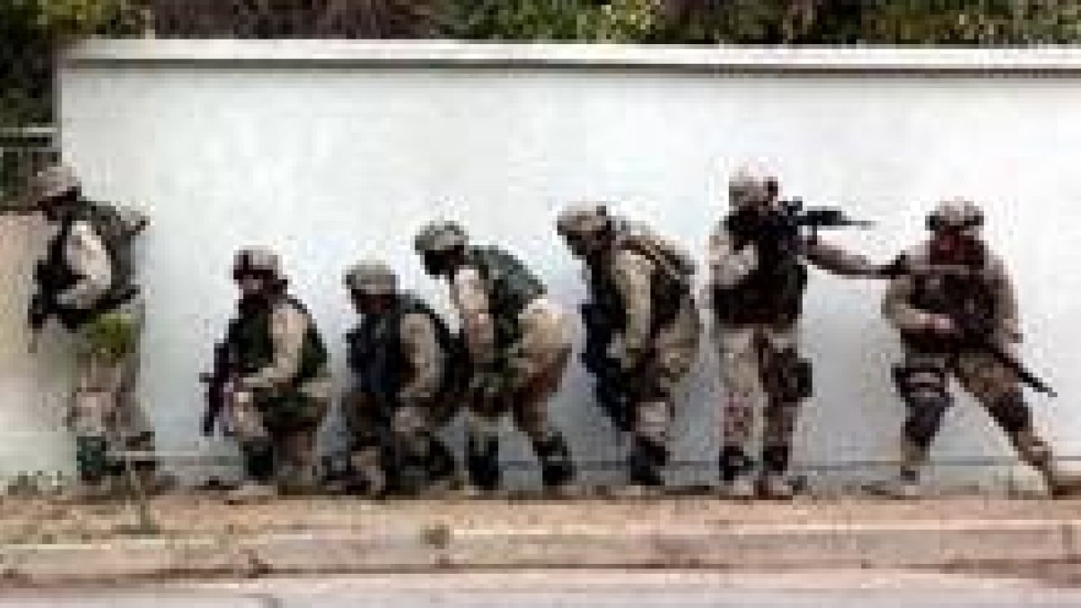 Un grupo de soldados norteamericanos se parapeta tras un muro en Bagdad