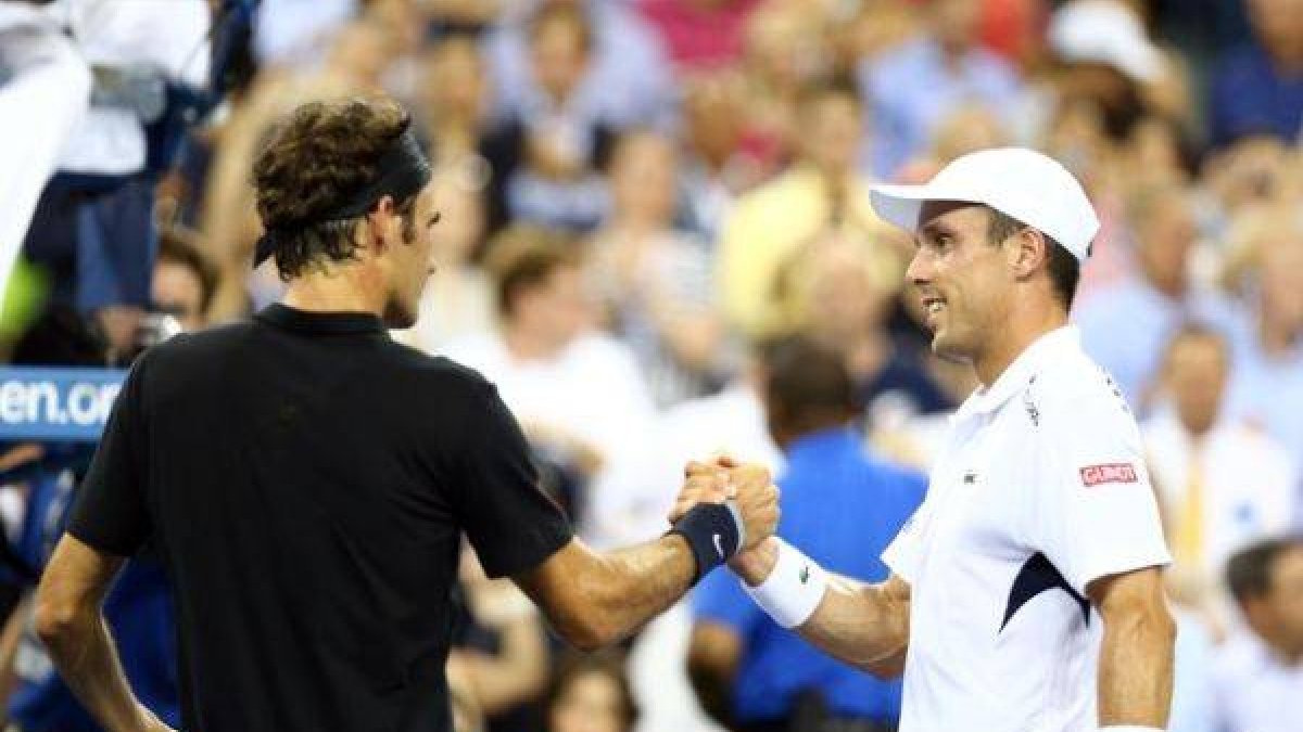 Federer y Roberto Bautista se dan la mano tras el partido.