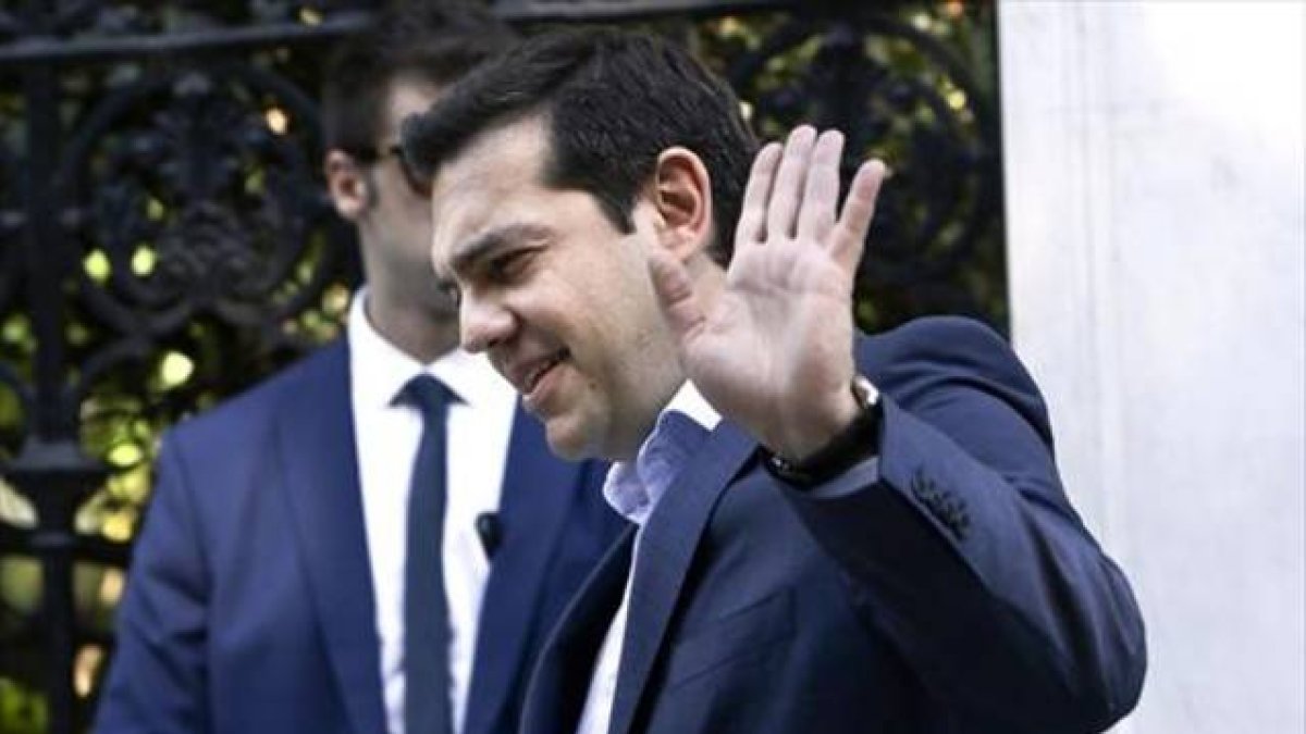 Tsipras saluda a la salida del palacio presidencial tras un encuentro con los líderes de los partidos.