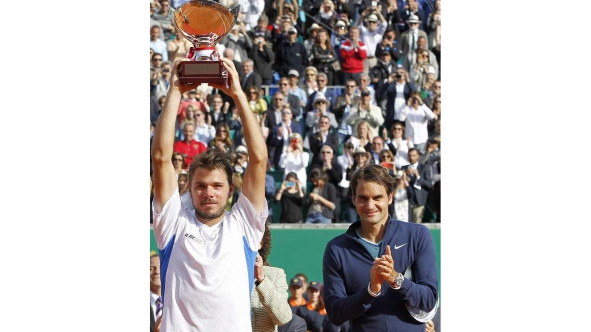 Wawrinka levanta el trofeo ante los aplausos de Federer.
