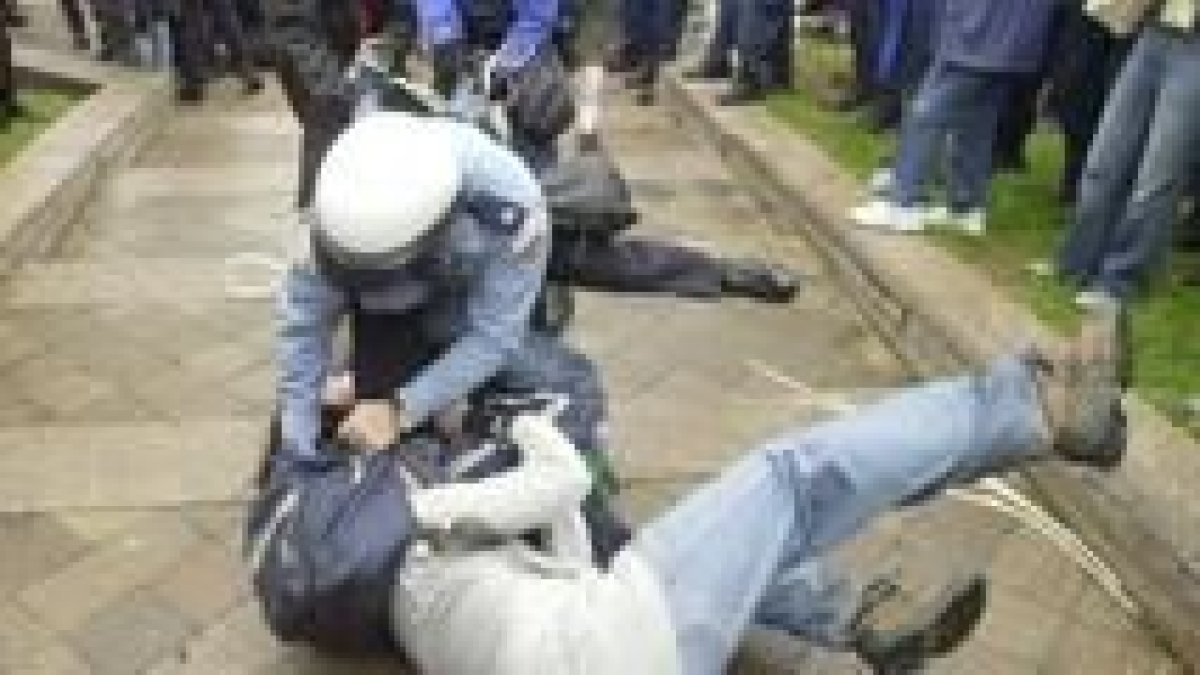 Un policía carga contra uno de los manifestantes contra el FMI