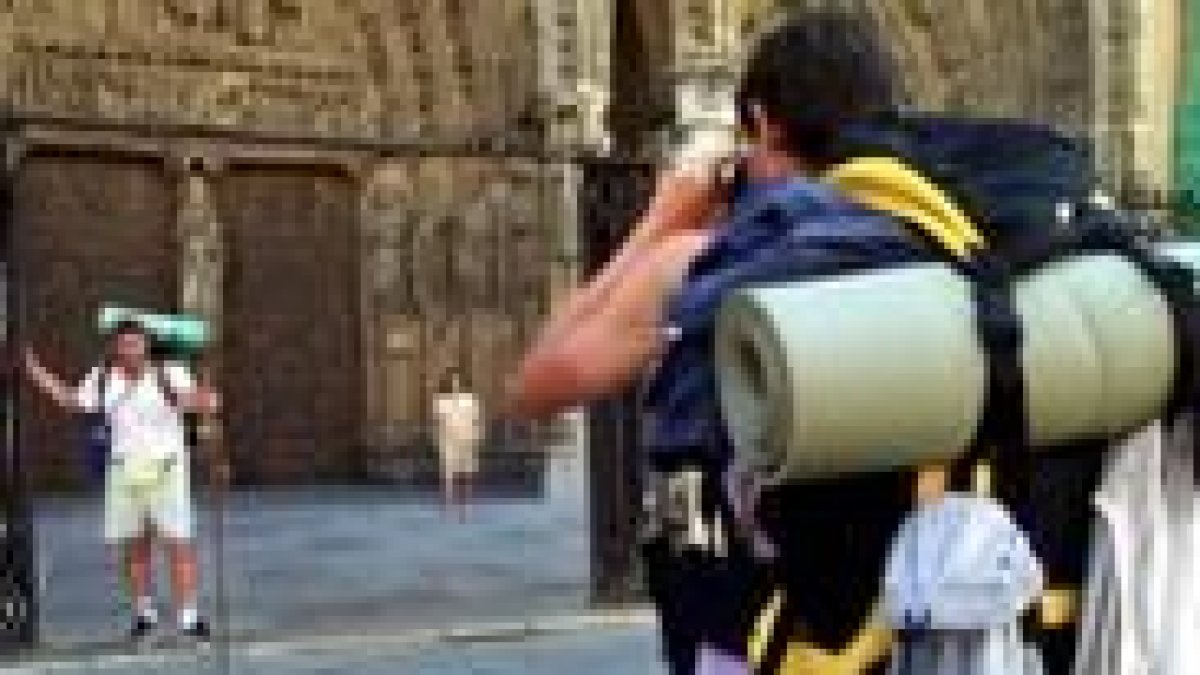 Dos peregrinos se fotografían frente a la Catedral de León