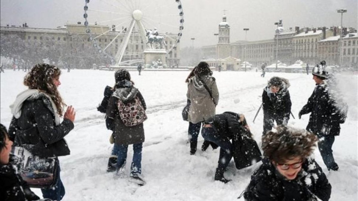 Niños jugando en la nieve en la plaza Bellecour de Lyon (Francia).