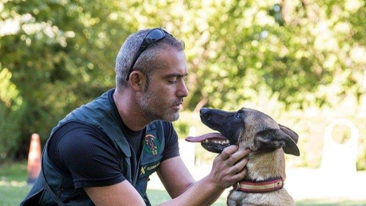 El guardia civil Ivan García con uno de los perros. COLPISA