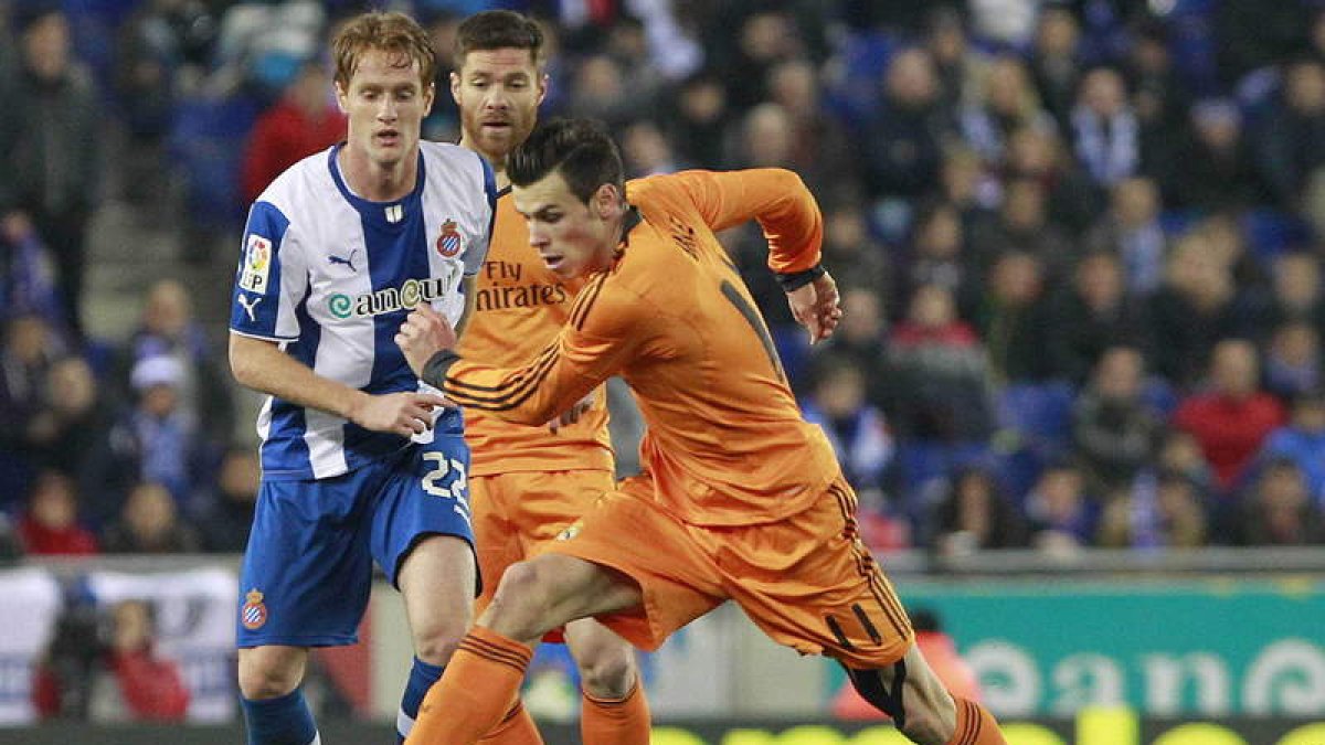 Gareth Bale intenta un disparo ante la mirada de su compañero Xabi Alonso y del jugador del Espanyol, Álex Fernández.