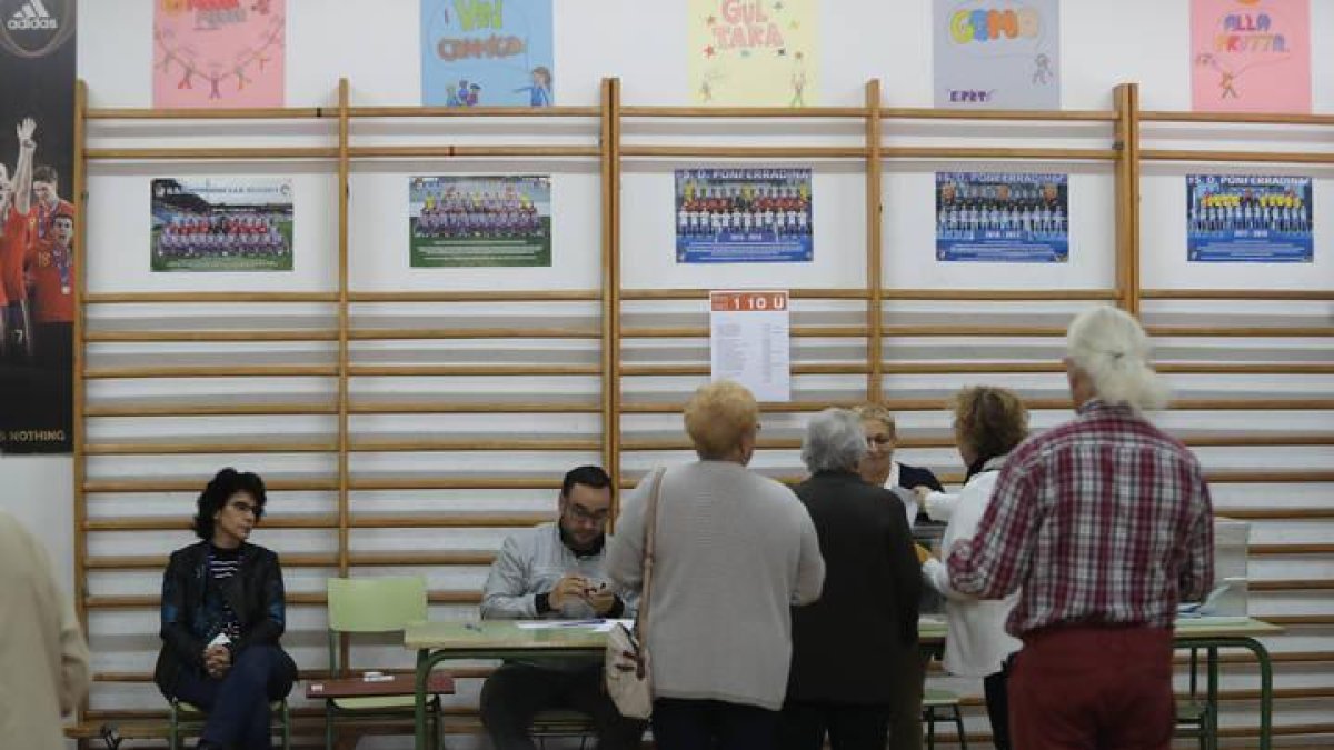 Unos ciudadanos votan en el colegio electoral de El Campo de la Cruz en Ponferrada.