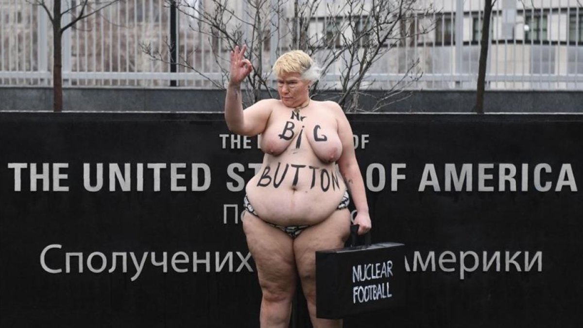 Una activista del movimiento Femen parodia a la mención de Trump sobre el tamño de su botón nuclear, ante la embajada de EEUU en Kiev (Ucrania).