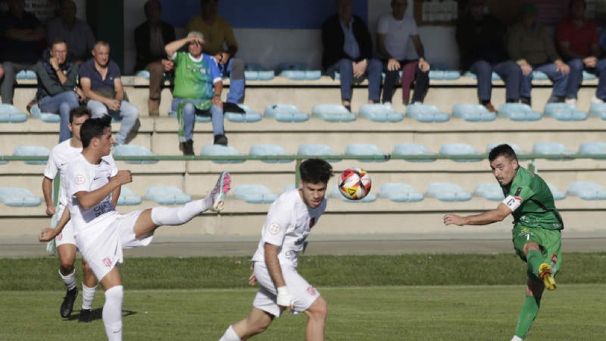 Diego Peláez golea el balón ante dos defensas rivales. FERNANDO OTERO