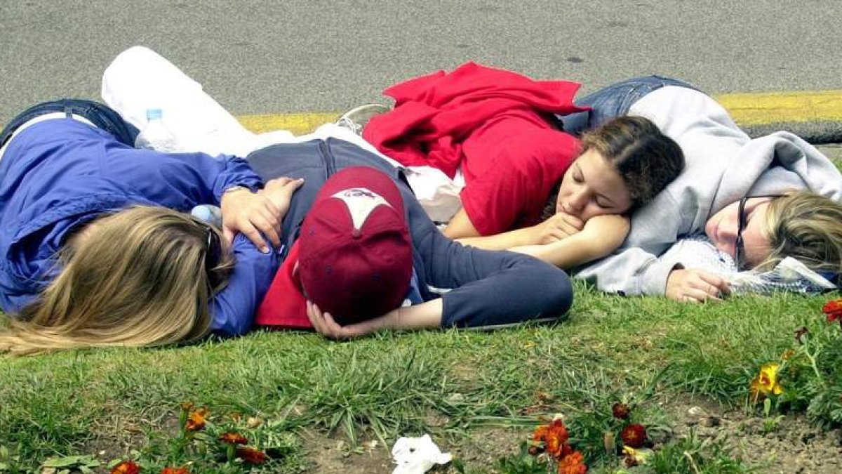 Cuatro jóvenes descansan en un parque en Pamplona durante san Fermín. IVÁN BENITEZ