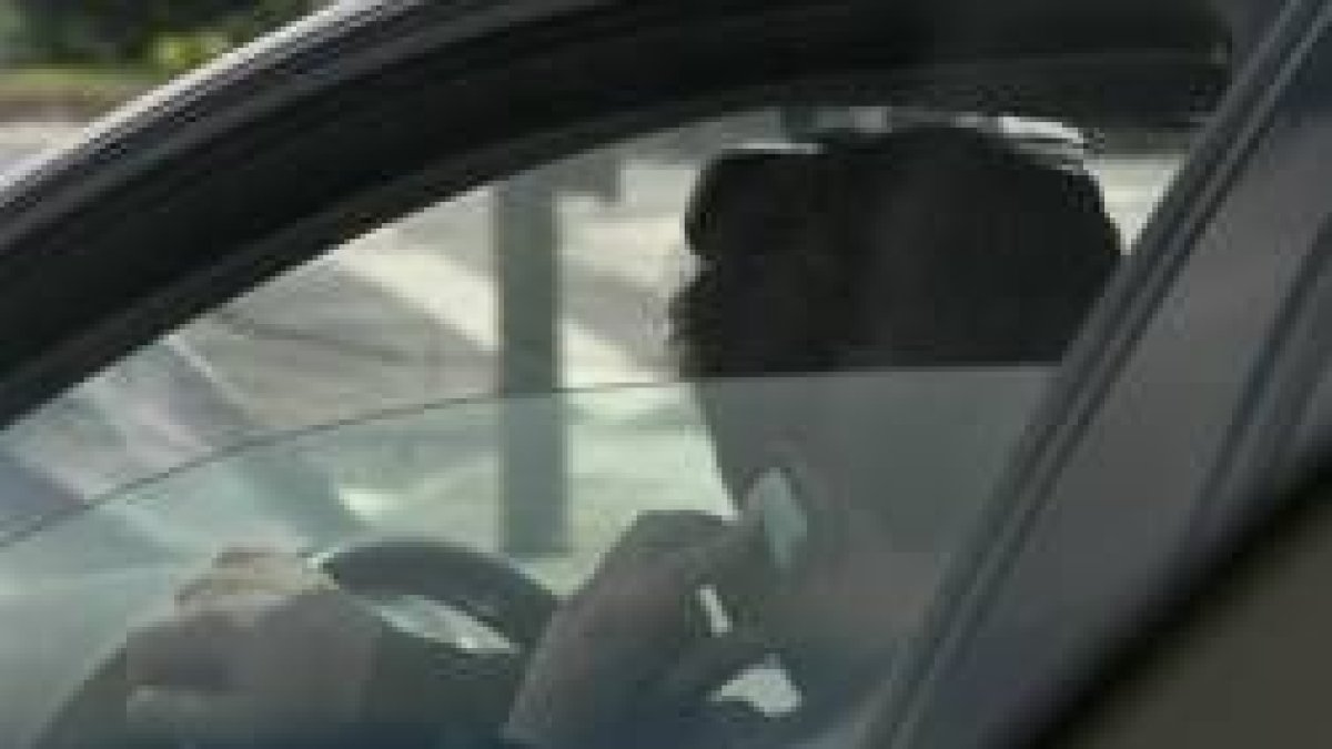 Imagen de un conductor hablando por el teléfono móvil mientras maneja el volante