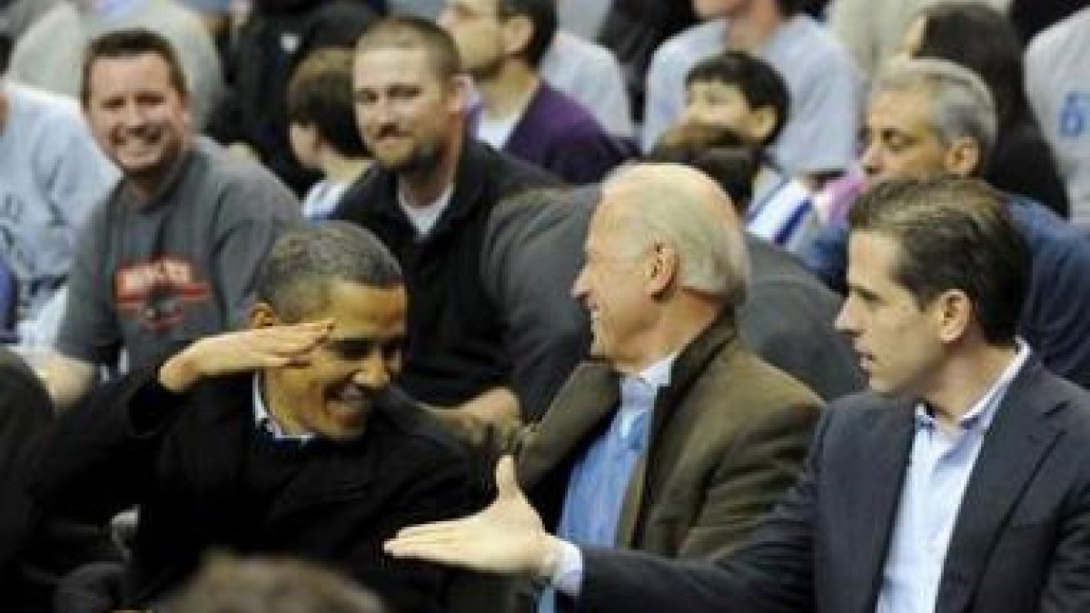 Obama saluda al vicepresidente Joe Biden, en el centro, y a su hijo Hunter en un partido.