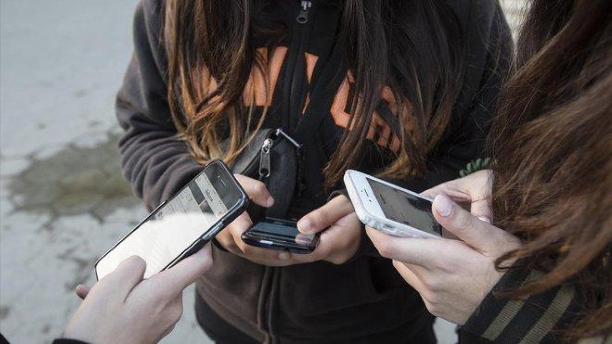 Unas adolescentes usan sus teléfonos móviles en Barcelona, en enero pasado.