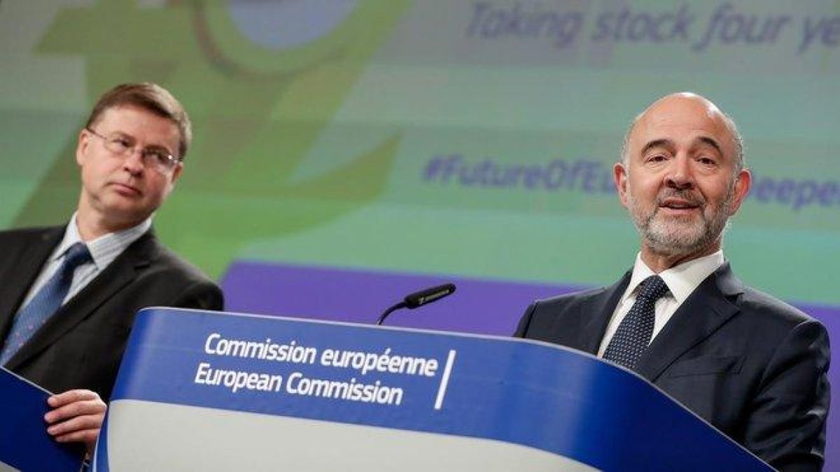 Dombroivskis (izquierda) y el comisario de Asuntos Económicos, Pierre Moscovici.