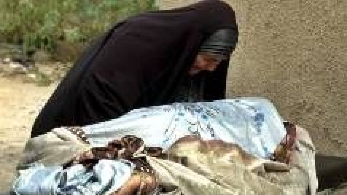 Una mujer iraquí llora sobre el cadáver de su hijo, aspirante a policía