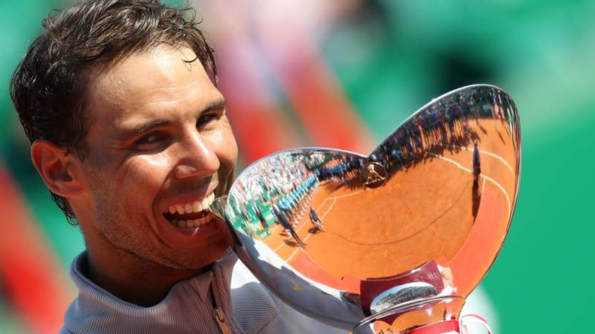 Nadal muerde la copa de campeón tras ganar a Nishikori en Montecarlo. SEBASTIEN NOGIER