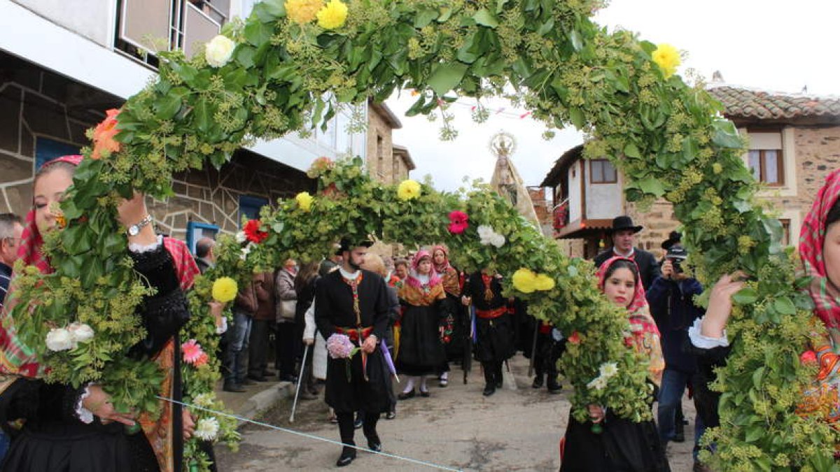 Las maragatas portan los coloridos arcos florales que preceden a la Virgen de los Remedios en la procesión