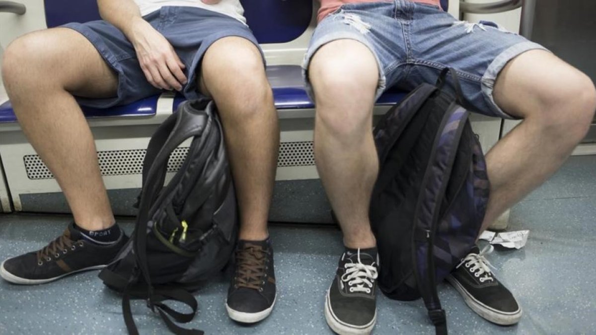 Dos viajeros del metro de Barcelona ocupan tres asientos con su 'despatarre'.