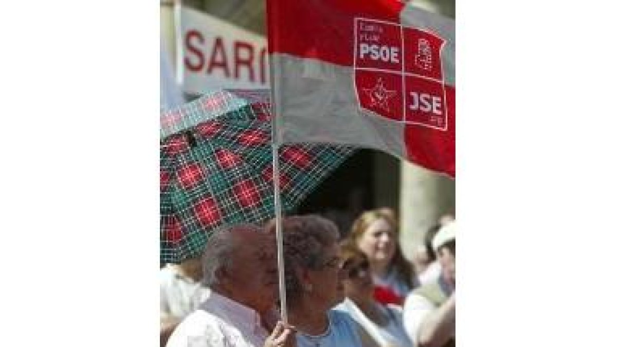 Dos asistentes se protegen de la fuerza del sol con un paraguas