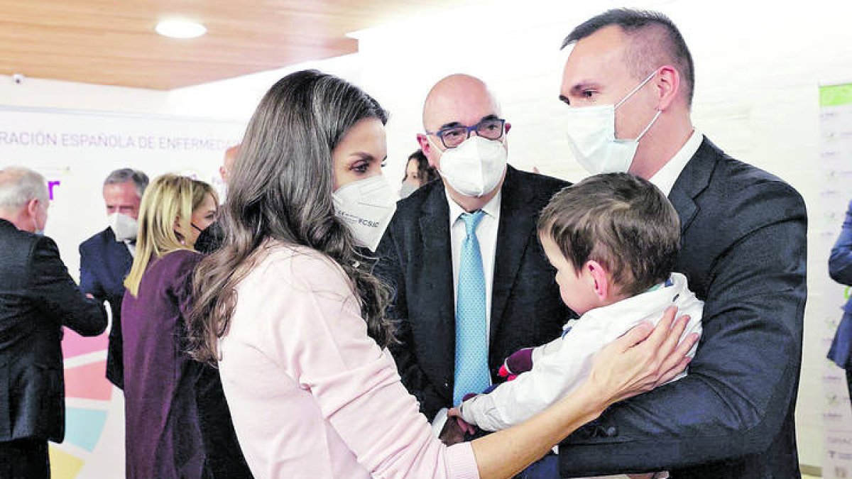 Letizia, en marzo del año pasado, acaricia a Marco en presencia de su padre, en el acto del Día Mundial de las Enfermedades Raras que se celebró en León. RAMIRO