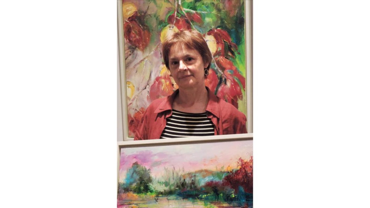 La pintora Michele Mariette, con dos de sus obras.