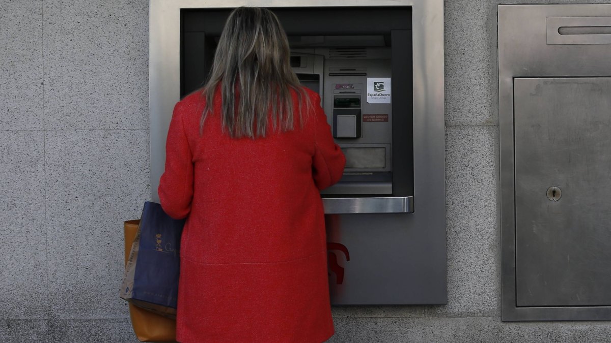 Una mujer saca dinero de un cajero automático en León. ARCHIVO