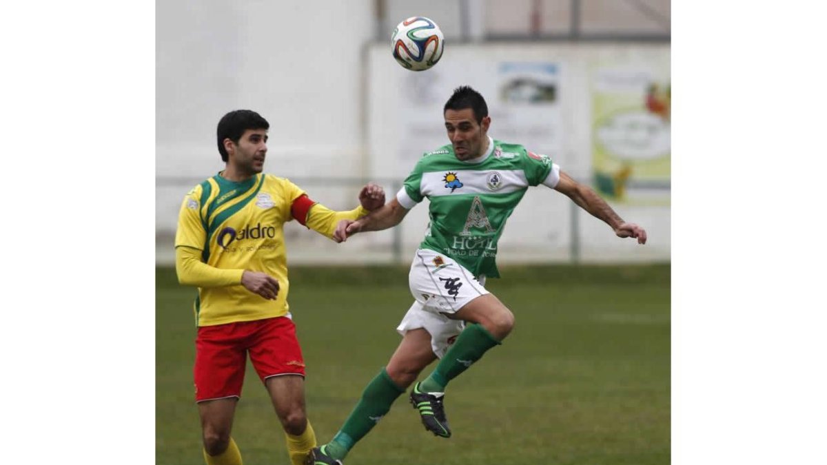 Porfirio recupera un balón a pesar de la oposición de Prado.