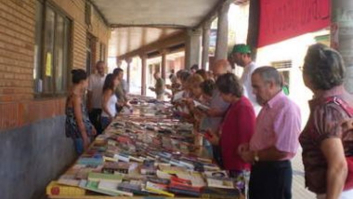 Varios vecinos ojean los libros que se ofrecieron en el mercadillo solidario.