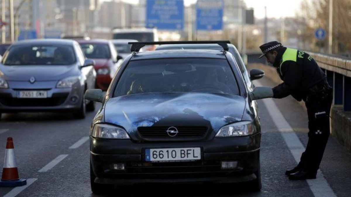 Un agente exige a un conductor con matrícula acababa en cero que dé media vuelta y no entre en Madrid, este jueves en la avenida de América.
