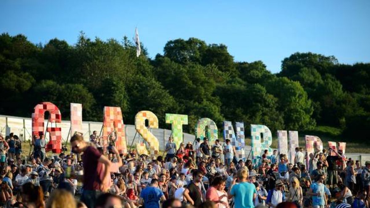 Algunos asistentes al festival observan la puesta de sol durante el primer día de conciertos en Glastonbury.