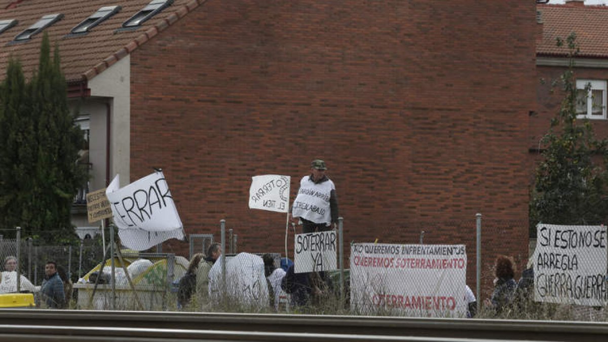 Vecinos y miembros de la plataforma por el soterramiento de Trobajo, junto a la valla del tren. FERNANDO OTERO