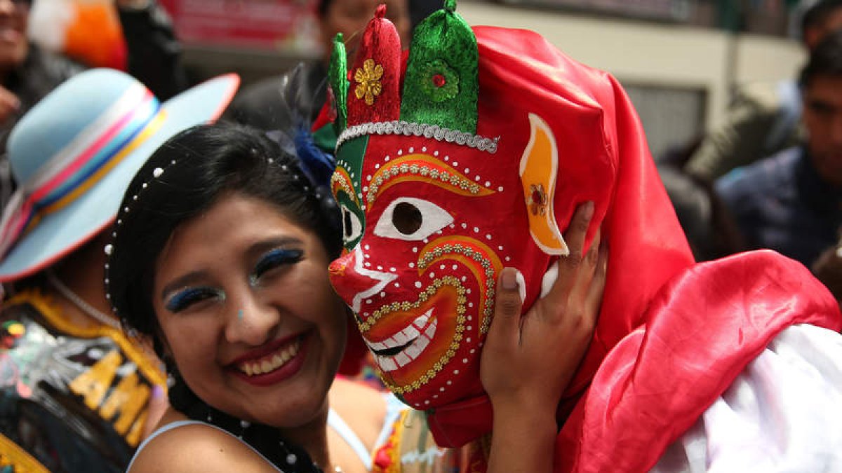 Una mujer posa junto al Pepino, el personaje más popular del carnaval de la capital boliviana. LUIS GANDARILLAS