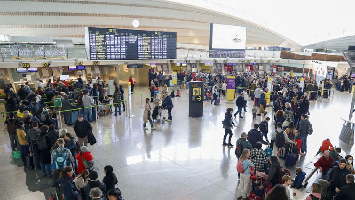Largas colas de viajeros este sábado en la terminal del aeropuerto de Bilbao. LUIS TEJIDO