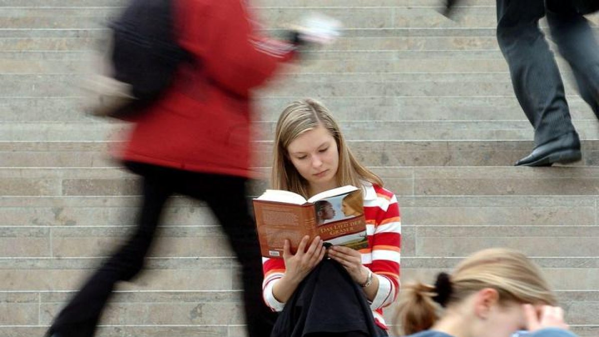 Una mujer lee un libro en plena calle
