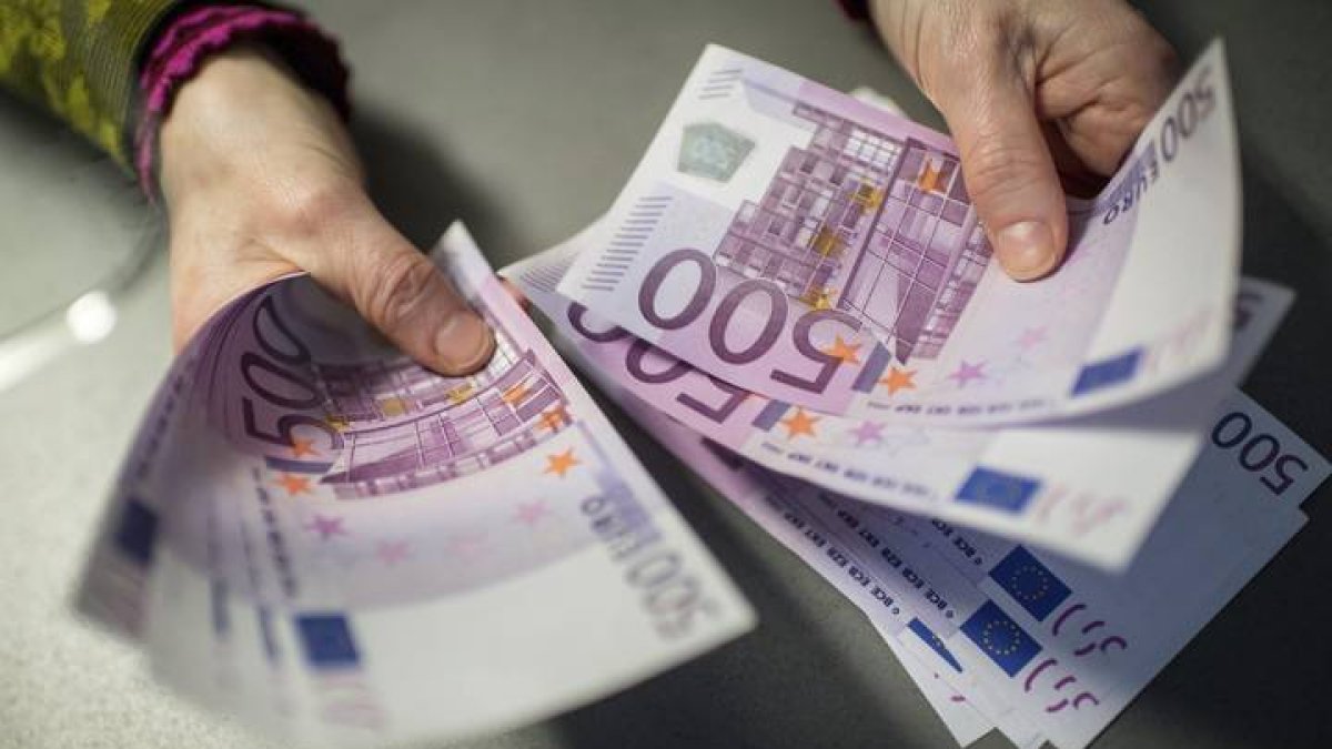 Un empleado de banca muestra 5.000 euros en billetes de 500 en el banco alemán.