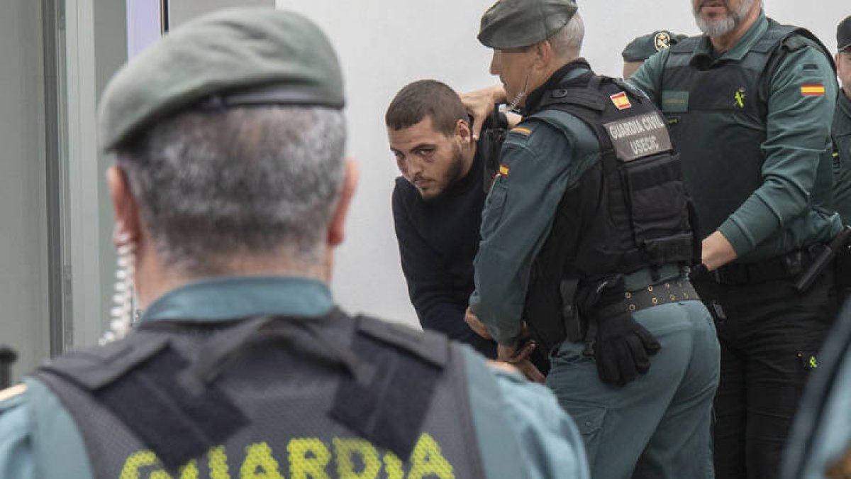 Agentes de la Guardia Civil trasladan a los juzgados de Barbate (Cádiz) a uno de los ocho detenidos por la muerte de dos guardias civiles a los que arrollaron con una narcolancha en la localidad gaditana de Barbate el pasado viernes, este lunes que han pasado a disposición judicial.