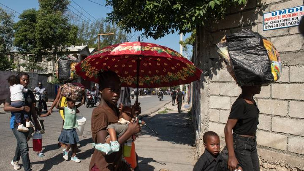Habitantes caminan por una calle este sábado en Puerto Príncipe (Haití). Presuntos delincuentes fueron abatidos por la Policía Nacional de Haití durante un ataque al Palacio Nacional la noche del viernes en Puerto Príncipe, orquestado por la coalición de bandas armadas 