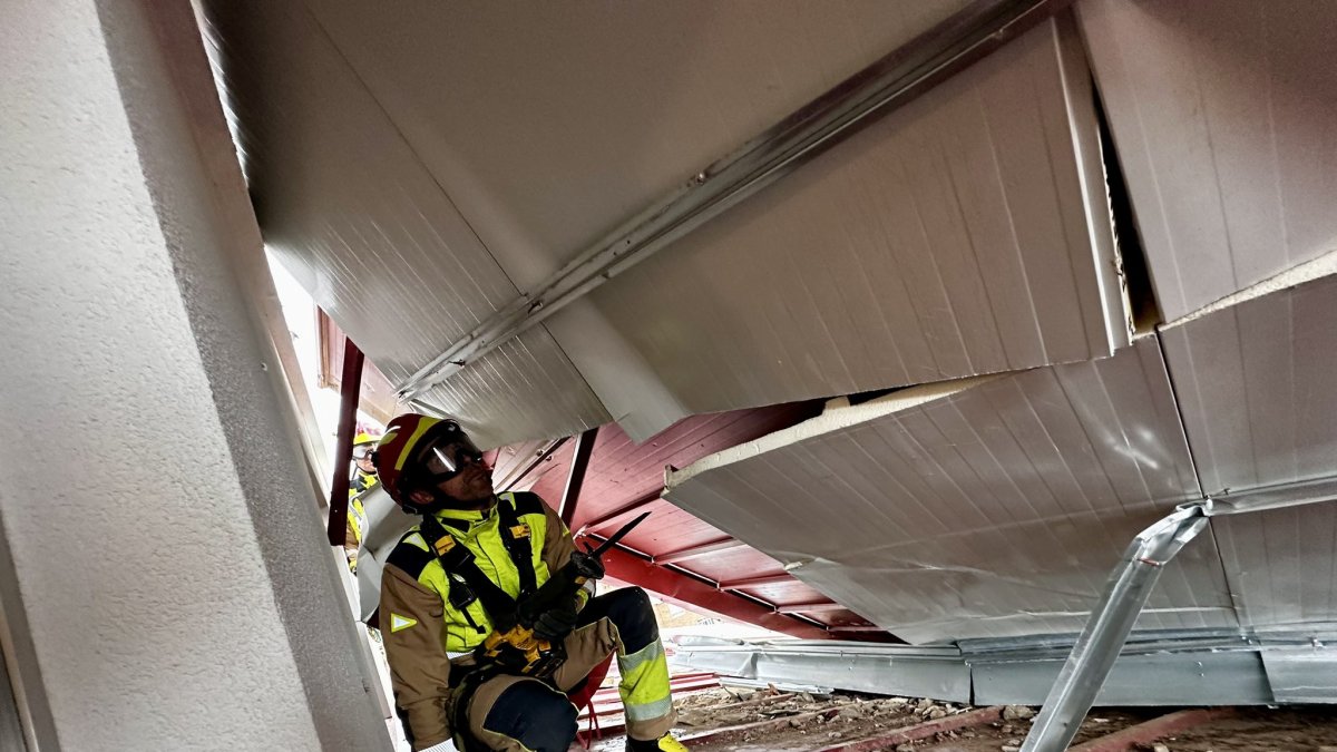Bomberos de León en la cubierta dañada este miércoles en Pinilla por el viento.