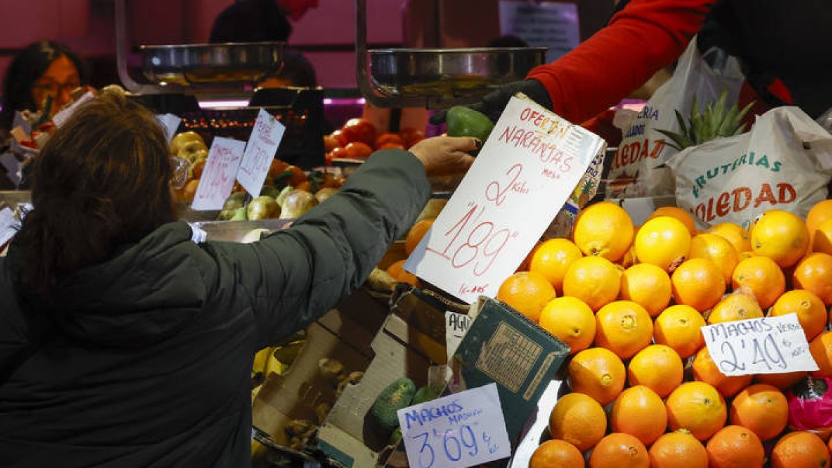 Una consumidora compra en un puesto de frutas y verduras en un mercado de abastos de Madrid, este miércoles.
